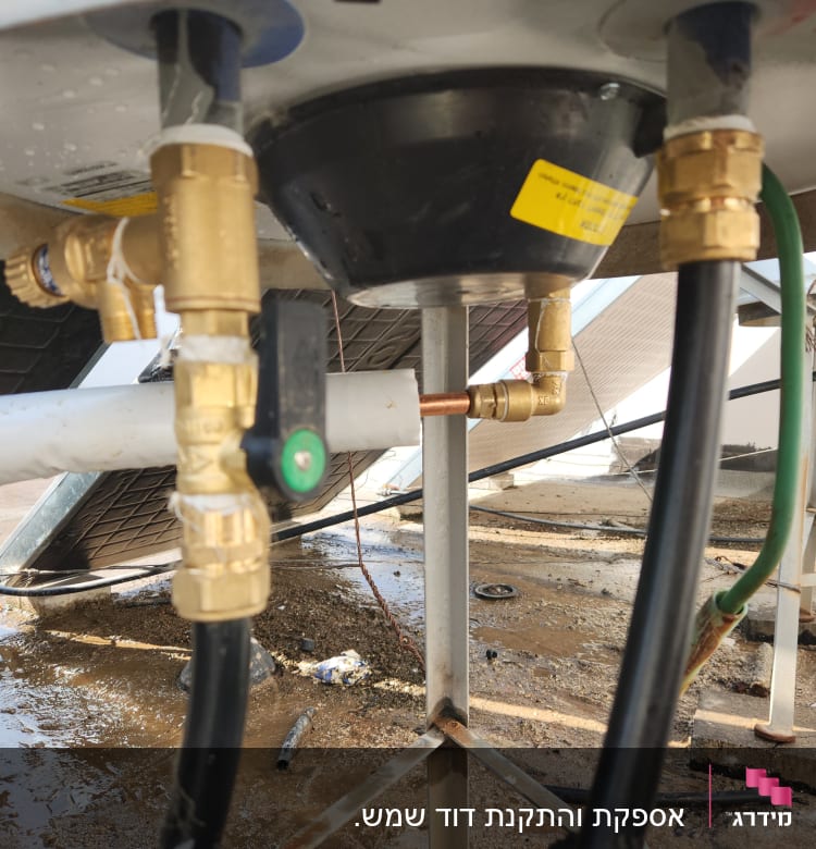 חיבורים וצינורות מתחת לדוד שמש על גג